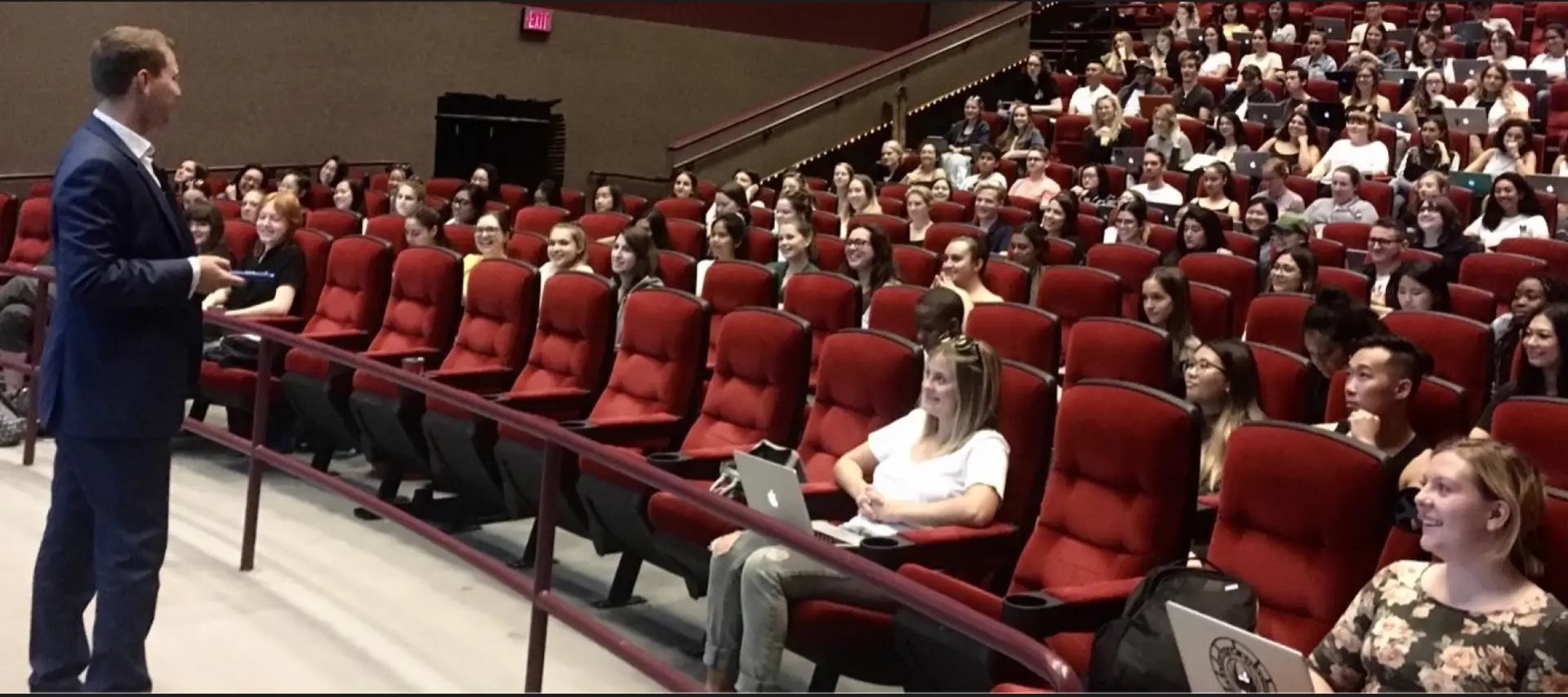 Corey Peck speaking to a full auditorium of students and professionals